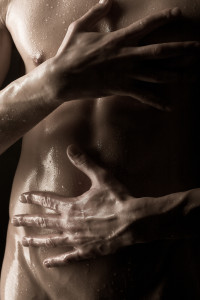 Picture of woman's hands wrapped around a sweaty man's stomach.