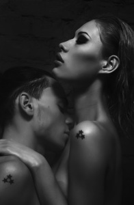 Black and white image of man kissing woman's neck
